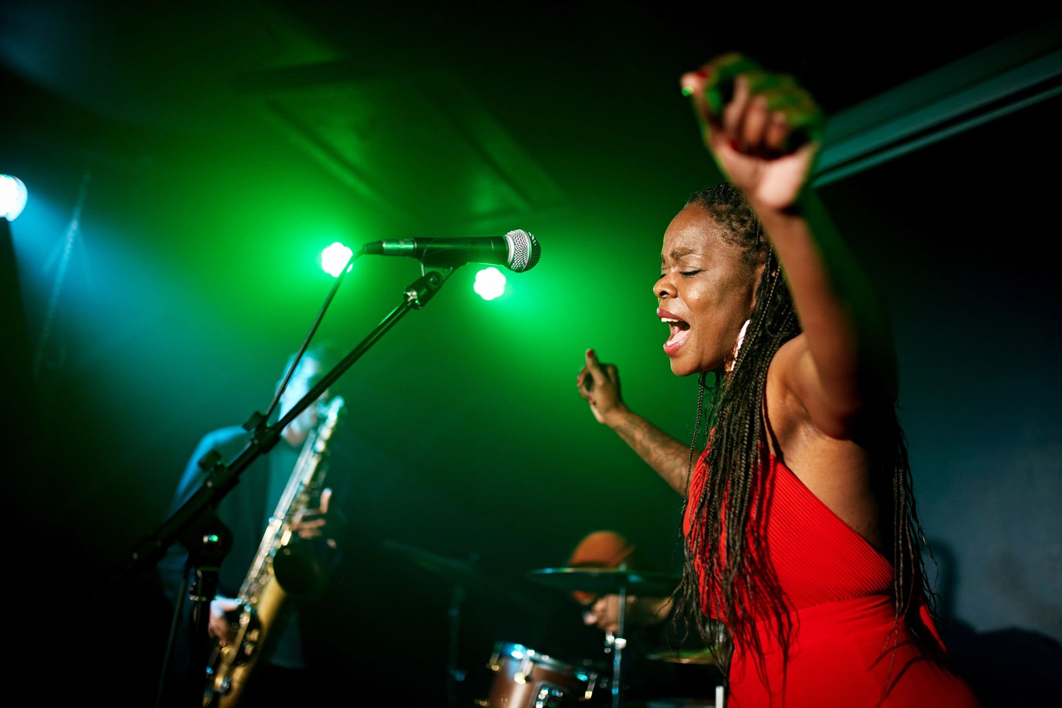 Singer performing in a nightclub with band behind