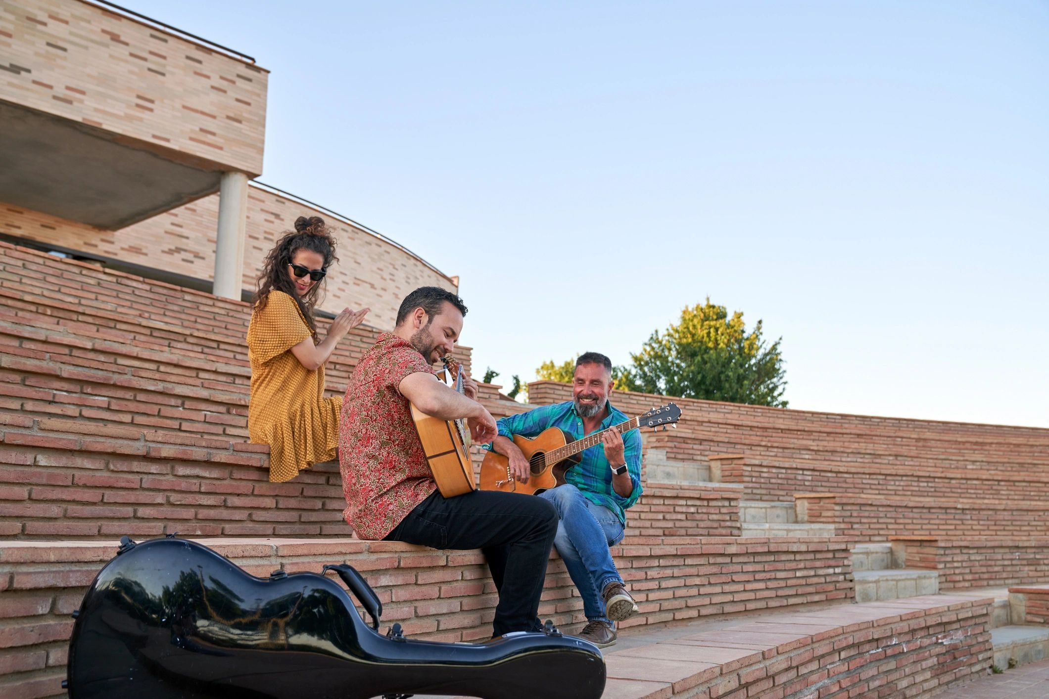 Friends playing acoustic guitars outdoors